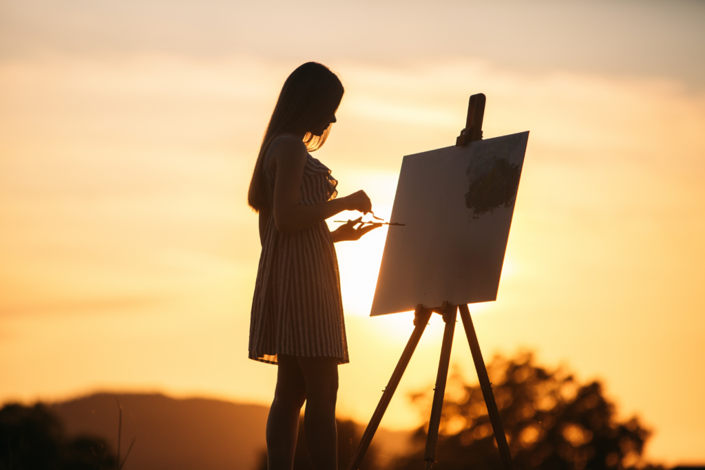 a girl painting on canvas showing art